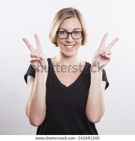 beautiful young woman making a victory sign isolated over white background