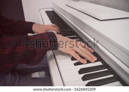 The hands of a musician playing the piano closeup