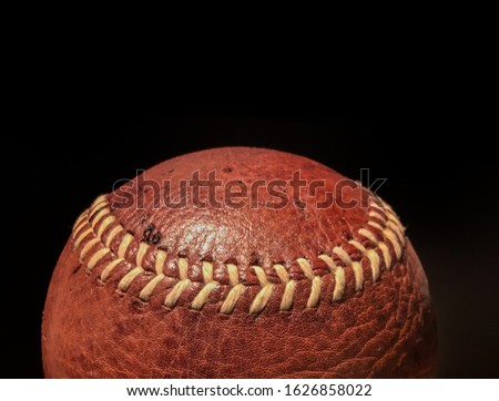 Vintage original  leather textured red brown softball baseball or cricket ball isolated against black background