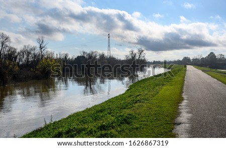 Paved bike path on top of earthen dike levee along Mississippi River in Louisiana  Royalty-Free Stock Photo #1626867319