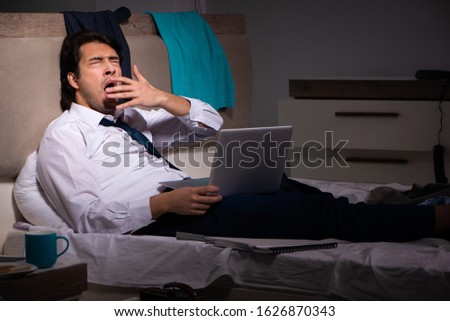 Young employee working at home after night shift