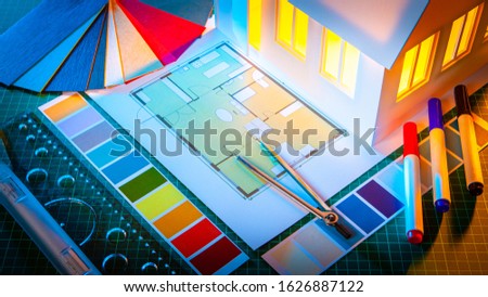 Architectural concept. Development of the concept of a new home. The company is developing a project of a cottage. Model house, construction documentation and color cards on the table of the architect