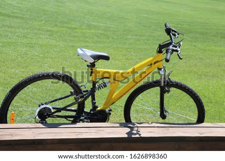Yellow bicycle on a background of green grass