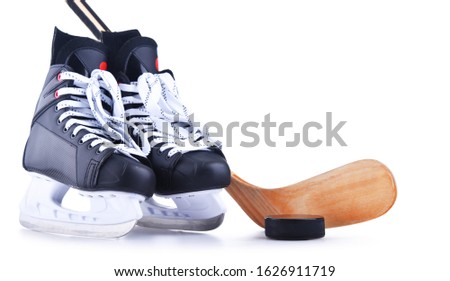 Pair of ice hockey skates with a stick and a puck isolated on white background.