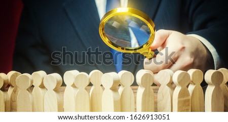 Businessman is studying a crowd of people with a magnifying glass. Hr search candidates for work, staff recruiting. Society, demographic. Market and customers research. Citizens electorate. Sociology Royalty-Free Stock Photo #1626913051