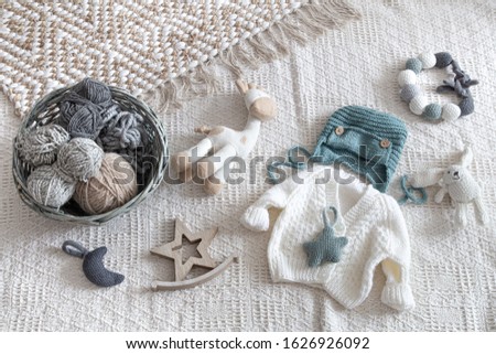 Set of children's stylish handmade knitted clothes with various accessories in the boho style, top view.