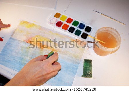 A palette of watercolors and brushes, accessories for the artist, a picture.