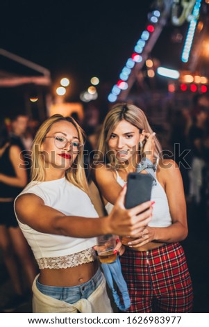 Two girls taking selfie in the amusement park