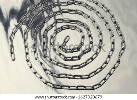 Blurred chain on shiny background, metallic steel texture with rhythms, chain spiral