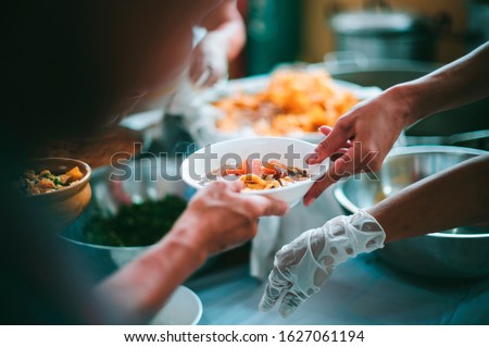 The hands of the poor are waiting to receive food from the rich, compassionate, free food donations to the homeless Royalty-Free Stock Photo #1627061194