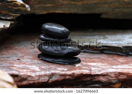 Zen stones, a symbol of balance, on rock waterfall.
