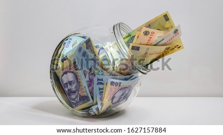 Glass Jar Full Of Romanian RON Bank Notes On A White Background Royalty-Free Stock Photo #1627157884