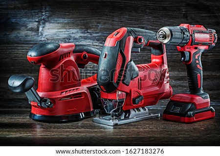 electric hand tools red corded jigsaw cordless drill and speed variable power small plunge router milling machine portable mini wood router on vintage wooden background Royalty-Free Stock Photo #1627183276