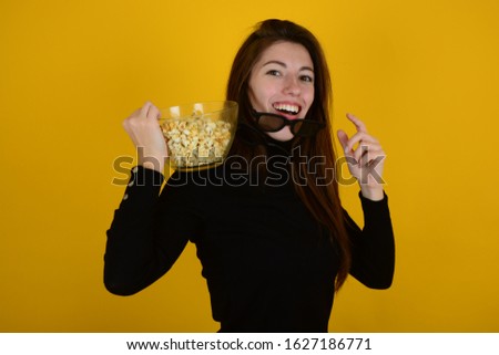 young woman in a movie theater with popcorn on a yellow background
