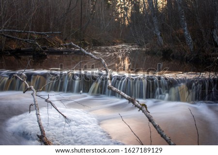 Beautiful long exposure Veldze waterfall with flowing stream water, late fall, Kurzeme, Latvia