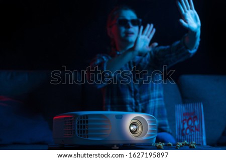 Cheerful viewing of a girl in 3D glasses at a home theater. Rest and relaxation