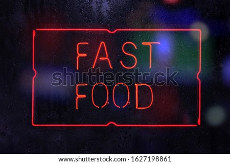 Neon Fast Food Sign in Rainy Window