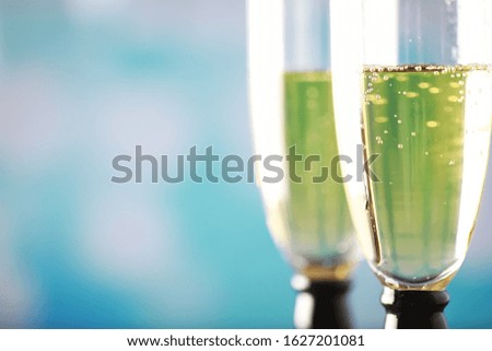 Background with tall glasses for sparkling wines. Champagne spray in glass glasses. Celebratory drink with reflection.