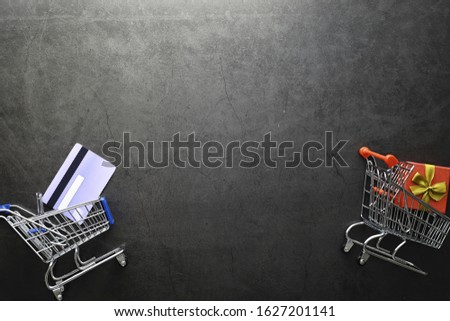 Shopping concept. Supermarket trolley, money and gifts on the background.
