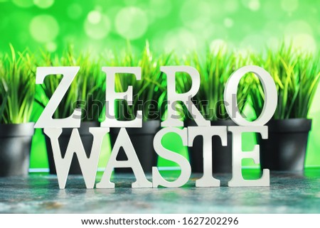 The concept of proper and environmental health. The inscription on a black background with wooden letters and paper elements. Free GMO. Zero waste.