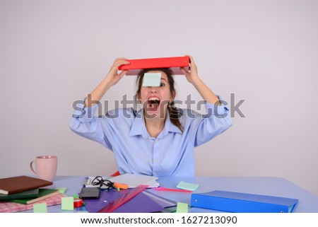 business woman holds a folder on her head shouting office emotions work