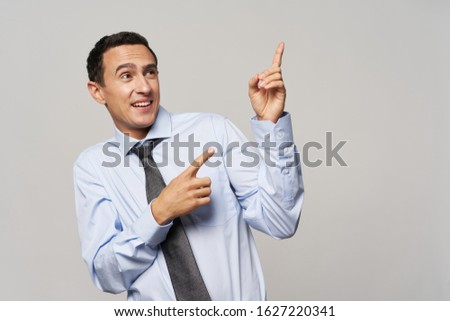 Businessman shows thumb up and business suit uncertain look