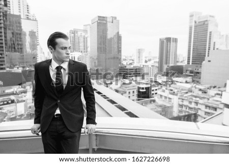 Young handsome businessman in suit exploring the city