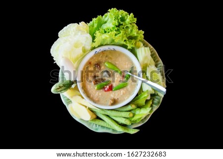 Crab dip with coconut milk and vegetables on black background, focus selective.