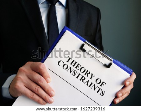 Businessman holds toc theory of constraints papers. Royalty-Free Stock Photo #1627239316