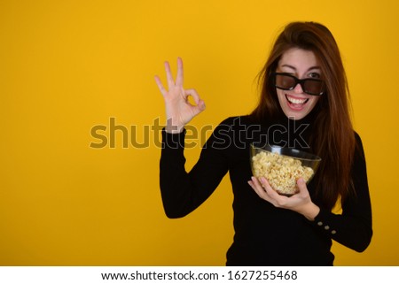woman in 3d glasses with popcorn shows ok isolated yellow background place free