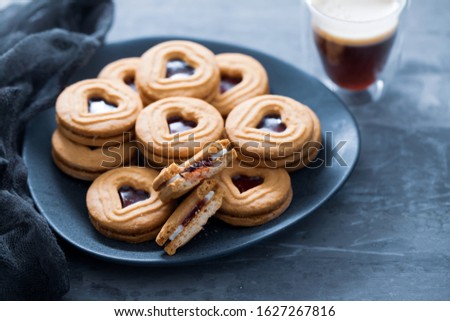 cookies with hearts on dark plate on ceramic background