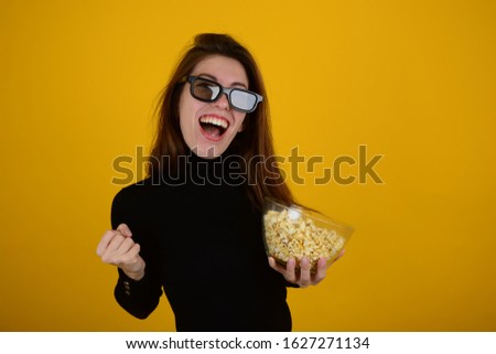 woman in black clothes with popcorn in the hands of the cinema