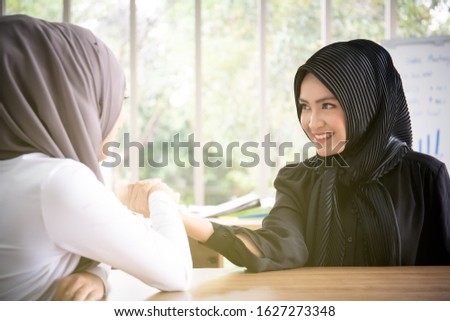 Asian Muslim woman doing a wrestle hands fight close up.