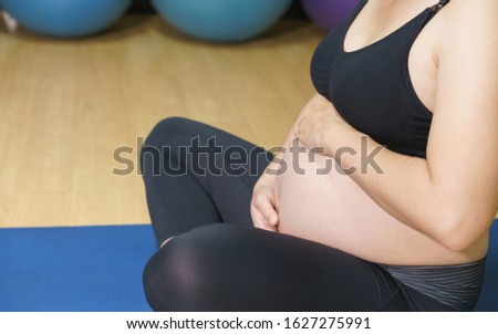 healthy pregnant woman doing yoga in gym. Working out, yoga and fitness, pregnancy concept