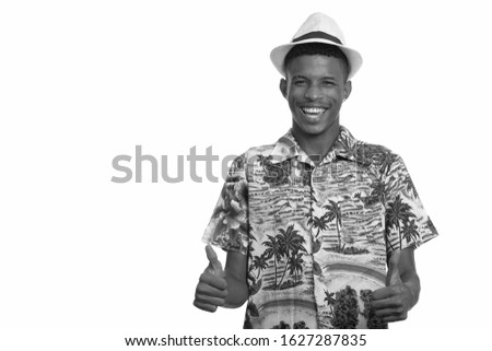 Young happy African man giving thumbs up ready for vacation