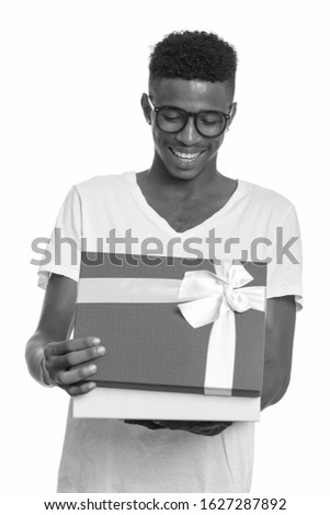 Young happy African man opening gift box ready for Valentine's day