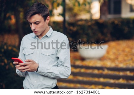Young man holding a phone in his hand.