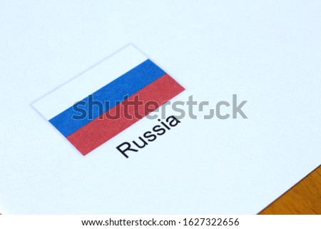 Russian / Russia flag in white paper on top of brown wooden table