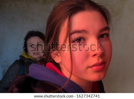 Teen girl face in red light and her mother in the background