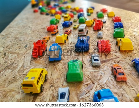 Top side view selective focus at the foreground miniature plastic car toys arranged -  congested traffic jam concept. 
