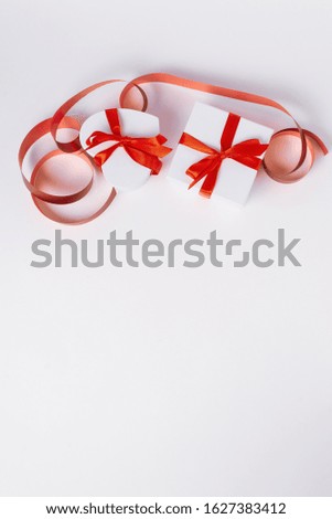 white gift boxes with red ribbon, presents or surprises for Valentine's day, birthday, international women's day or for celebrating other holidays or events on a white background. Top view. Copy space