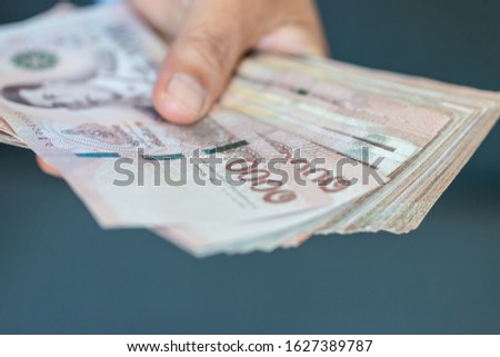 Blurred of Stack Thai baht banknotes, one thousand baht with tag text in Thai word. (THB) is official currency of Thailand. Finance and banking business Exchange rate in Asia Royalty-Free Stock Photo #1627389787