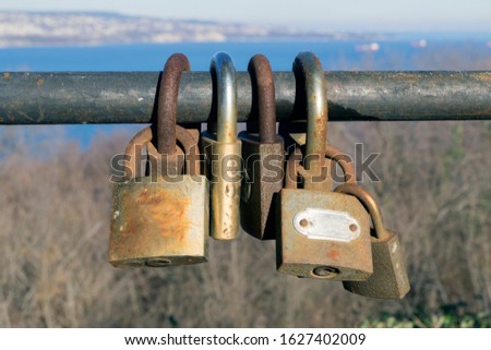 
old metal locks hang on an iron fence