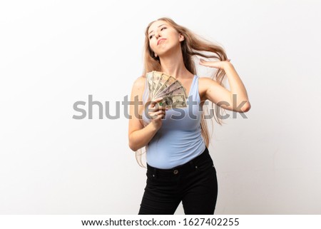 yound blonde woman feeling stressed, anxious, tired and frustrated, pulling shirt neck, looking frustrated with problem holding dollar banknotes