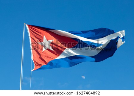 Cuban flag waving in the wind against the background of the moon