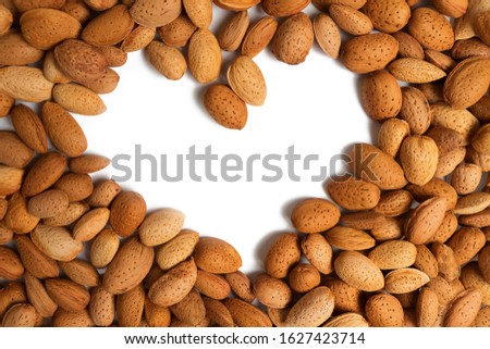 almond heart. copy space in the shape of a heart on a background of unpeeled almonds