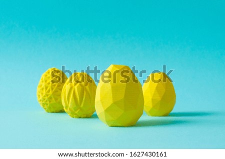 Easter minimalistic decor concept. Yellow geometric Easter eggs on blue background with blank space for text.