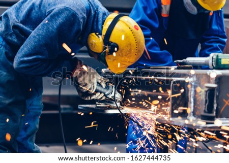 Worker grinding in a workshop. Heavy industry factory, metalwork Royalty-Free Stock Photo #1627444735