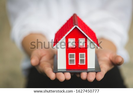 Red roof house on hand, sales representative. Sign contracts, signatures on official documents, customer partners, customers who purchase products or sign contracts, home trading ideas.