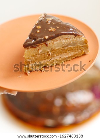 peace of cut pear caramel cake with cream mousse and chocolate glaze with nuts close up photo
